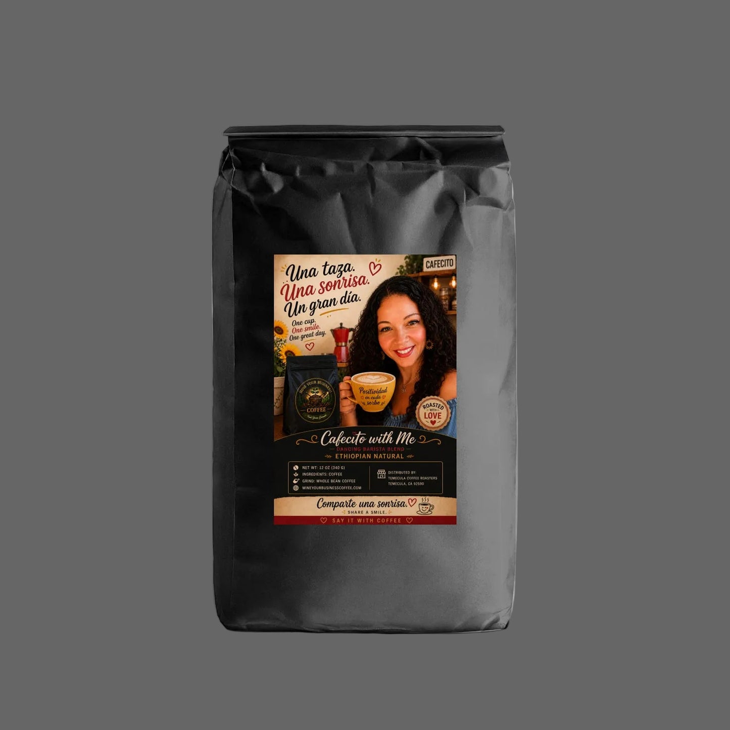A black bag of coffee with a colorful front label featuring a smiling woman and Spanish text, photographed on a clean white background.